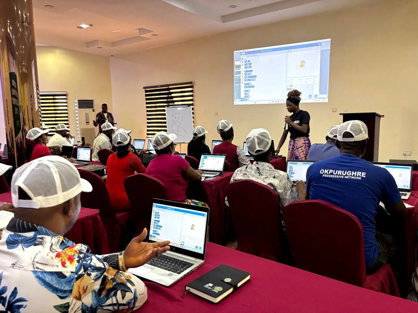 Instructor presenting Scratch on a projector to a classroom of teachers